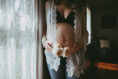 pregnant maternity mom holds belly with flowers