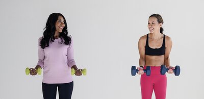 Deme Riley working with a woman holding free weights.