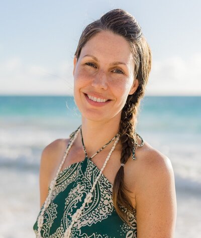 Woman with braided hair smiling while dressed up at the beach