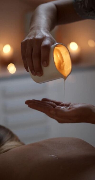 melted wax being poured into hand for massage