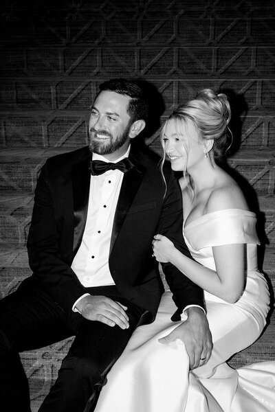 Romantic image of bride and groom on steps of building captured by luxury photographer Revel Photography