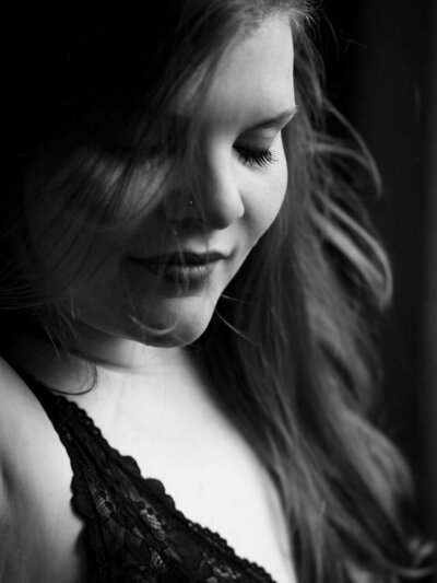 Verführerisches Lächeln: Frau in feinen Dessous, ein ästhetisches und intimes Boudoir-Foto