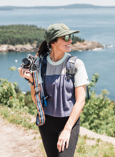 A photo of a woman taking a photo with mountains behind her