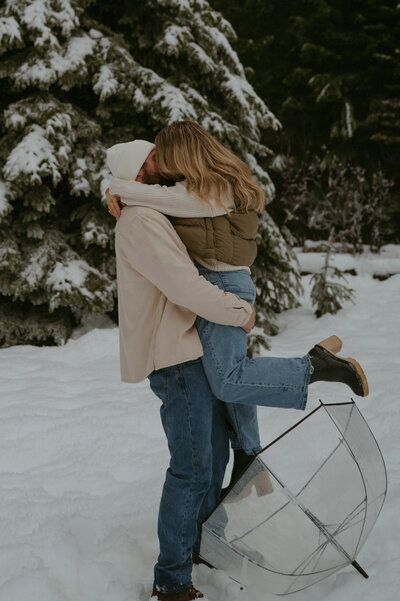 couple standing in the snow kissing