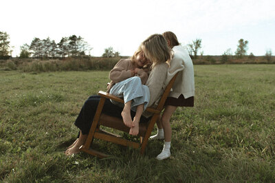 a mother and her daughters in a rocking chair documented by a Sudbury Documentary Photographer
