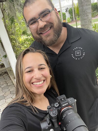 man and woman holding camera and smiling