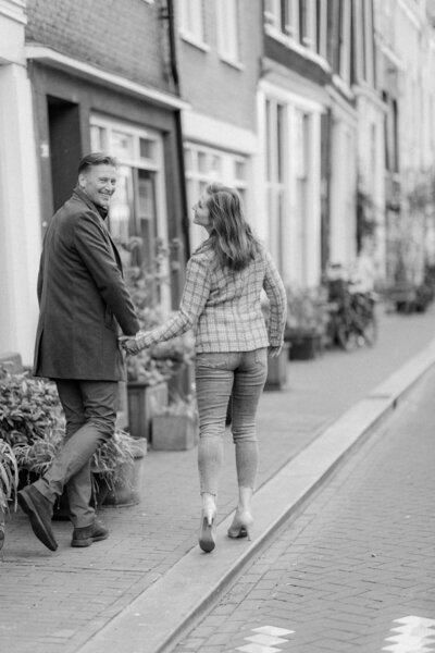 Een verliefd stel geniet van een spontaan moment tijdens een loveshoot in Amsterdam