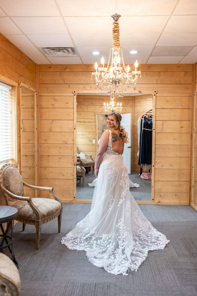 Bride posing in bridal suite with chandelier reflection
