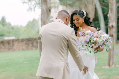 Bride and groom during their first look at Poplar Springs Manor in Virginia, with the bride holding a romantic bouquet of mauve roses, lilac, and white blooms. Luxury wedding flowers by Springvale Floral, serving high-end weddings in Washington DC, Virginia, and Maryland.

