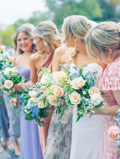 Elegant bridal bouquet with blush pink roses, white peonies, and greenery designed by Leigh Florist, captured at a romantic outdoor wedding.