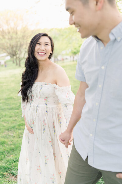 A pregnant woman holds her husband's hand and walks through Nemours Estate in Wilmington, Delaware.