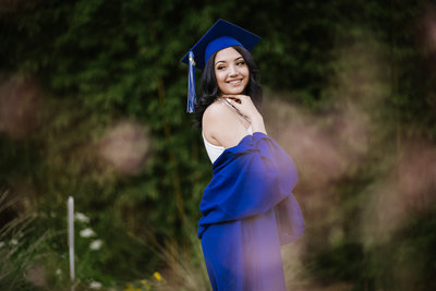 High School Senior portrait of girl in blue graduation gown taken at Landa Library in San Antonio