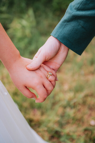Two people hold hands on their wedding day