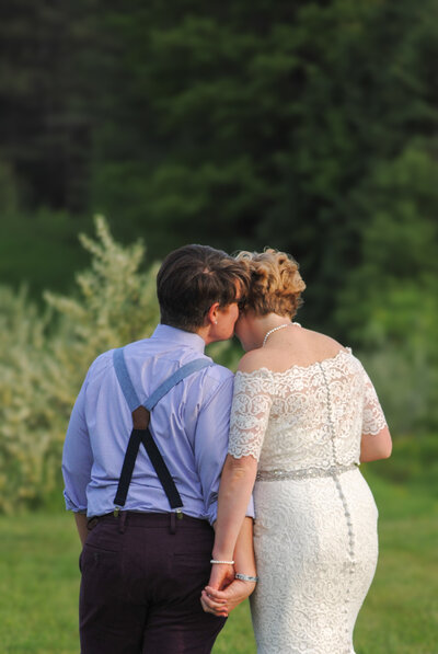 Maine LBGQ wedding couple holding hands and sharing a kiss.
