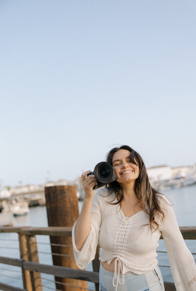 girl holding up camera and smiling