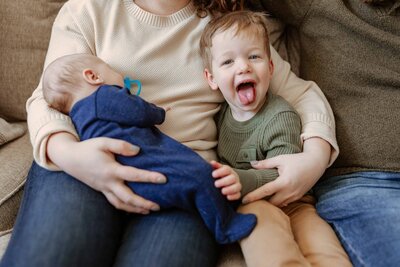 Silly older brother giggling during newborn session