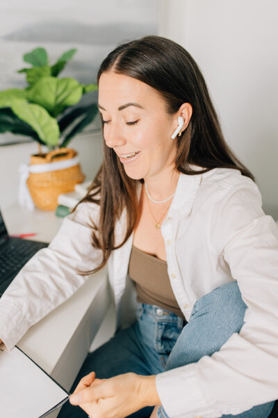 Man sitting in a chair at a table working from home at a laptop