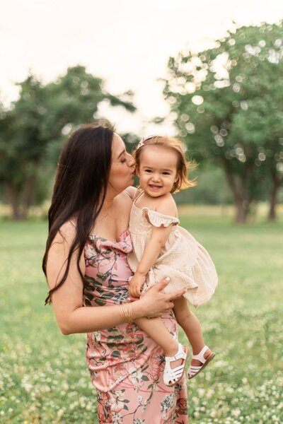 mom kissing baby on side of face