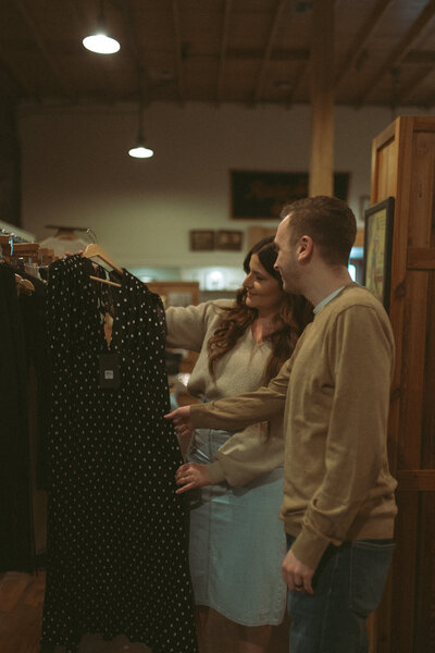 a couple shopping together, looking at clothes in a downtown lafayette boutique.