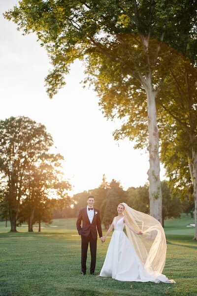 couple at sunset with veil floating at saucon valley country club
