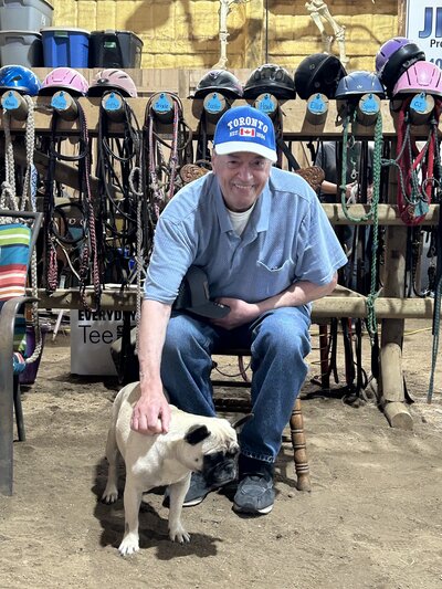 A senior man petting with a dog at Spirit's Respite Ranch in Alberta.
