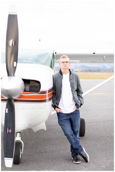 High school senior sits in front of his plane for Hamilton Montana senior photos