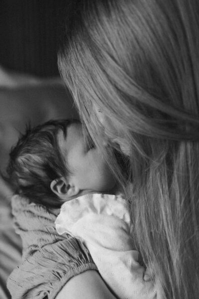 Een kersverse moeder geeft haar dochtertje een kus op haar neusje. Een intiem en teder moment, vastgelegd door Sharon Kastelijns Photography.