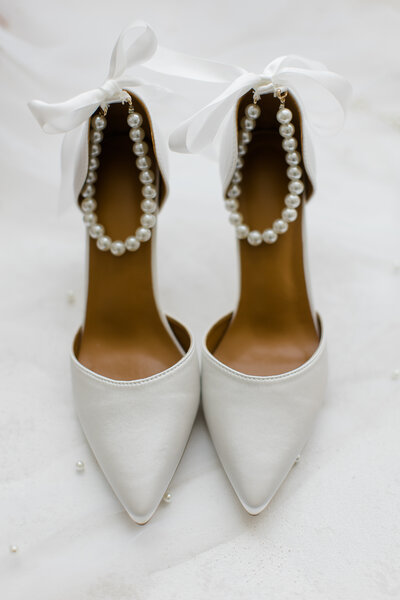White bridal heels with pearls and white ribbon bows