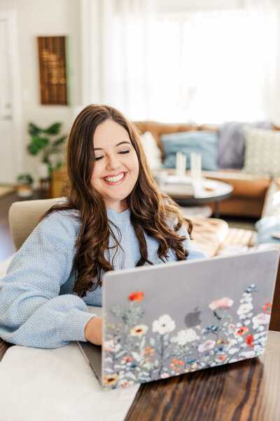 Ivy smiling while working at her laptop