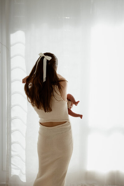 sibling newborn photography, sister holding her newborn baby sister in the Brookwater Studio Space