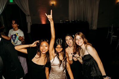 A group of teens poses playfully on the dance floor during a celebration at SoHo63, a Chandler wedding and event venue. With party dresses, big smiles, and energetic poses, the moment captures the fun and excitement of hosting teen events, proms, and parties at SoHo63.