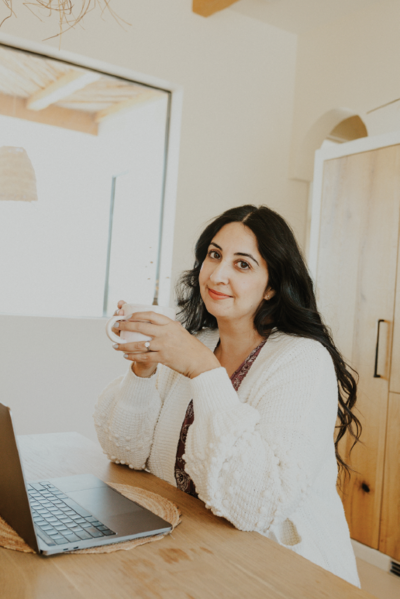 harleen-holding-mug-with-Harleen holding mug with laptop