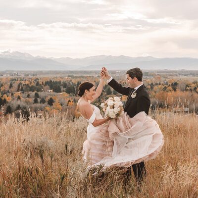 bride and groom dancing in a field of wild grass