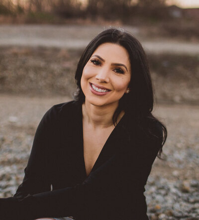 Close-up headshot of Angelica Ray, a spiritual guide and healer, smiling warmly against a serene outdoor background.