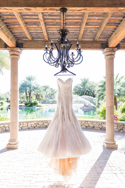 Stunning elegant Kleinfeld Bridal wedding gown hanging in mansion by lake