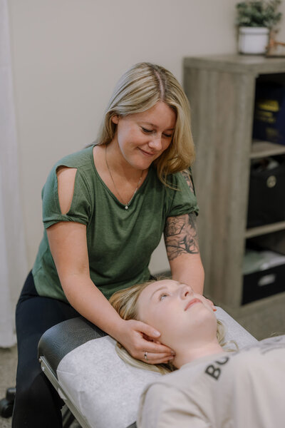Dr. Brittany Fisk applying hands-on spinal care to improve posture and reduce back pain at Busy Bee Chiropractic.
