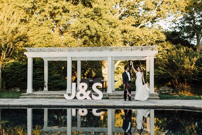 Bride and Groom twirling beside reflection pool at Cedarmont Farm