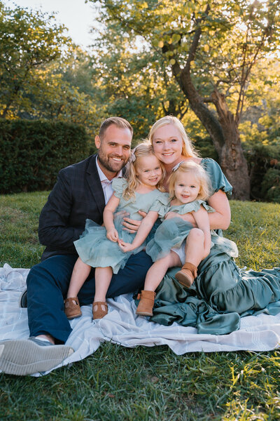 Young family sitting in lawn of Kansas City museum during Emma Leigh Studios fall family mini sessions.