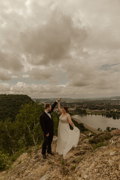 MinnesotaCliffside wedding photos of couple spinning on Garvin Heights, Winona, MN