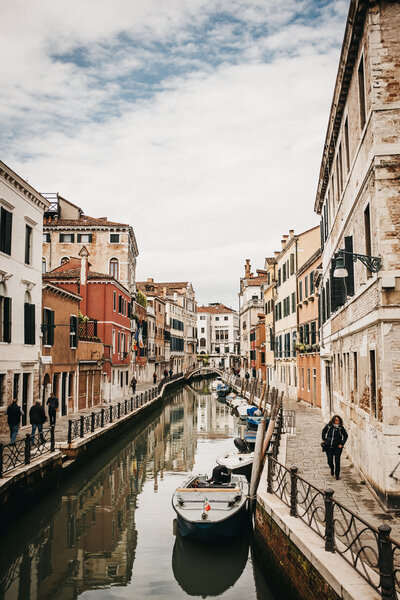water canal, people walking, and colourful italian buildings