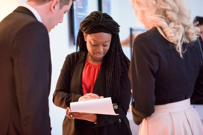 LaToya speaking to colleagues and checking some printed pages