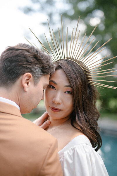 couple stands together with elegant sun crown on her head