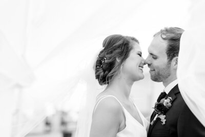 Bride and groom about to kiss under a veil