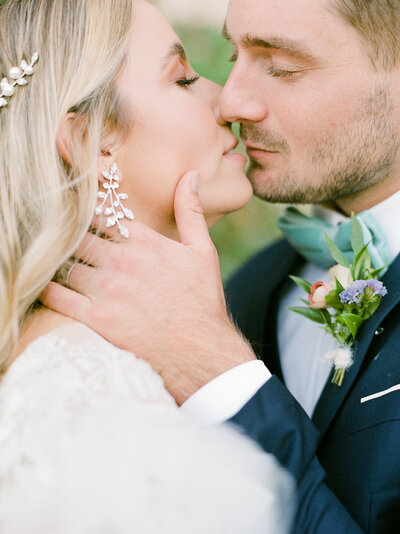 a bride and groom almost kissing in a close up intimate photo with their eyes closed
