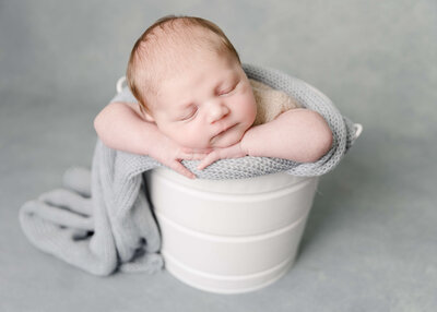 Baby boy posed in bucket by Ashley Nicole Photography