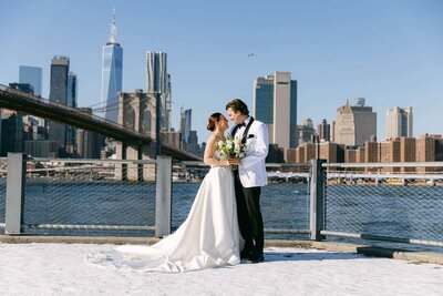 Couple try to stay warm on Brooklyn Waterfront on their wedding day in Winter,