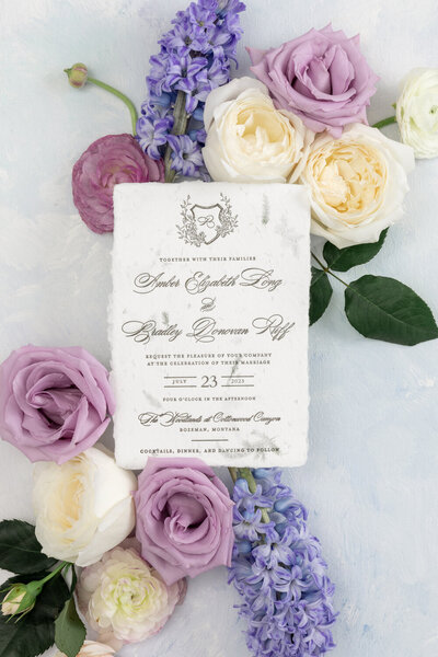 Distinctive wedding invitation idea featuring a letterpress design with a monogram on pine-scented handmade paper embedded with real pine pieces.