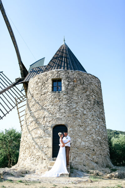 bride-and-groom-embrace-next-to-windmill-at-luxury-wedding-in-st-maxime