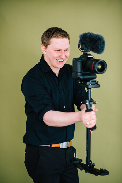 Jackson Hole wedding photographers captures Jackson hole videographer smiling and holding camera