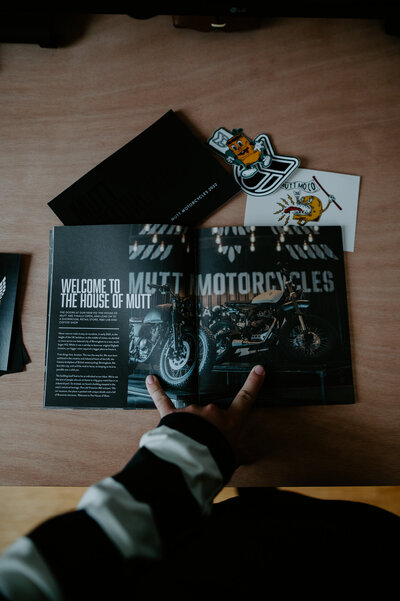 Hand opening a Mutt Motorcycles book